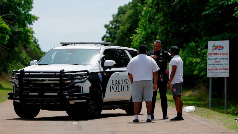 Police talks to two guys at the entrance to Scissortail Campground at Arcadia Lake in Edmond,...